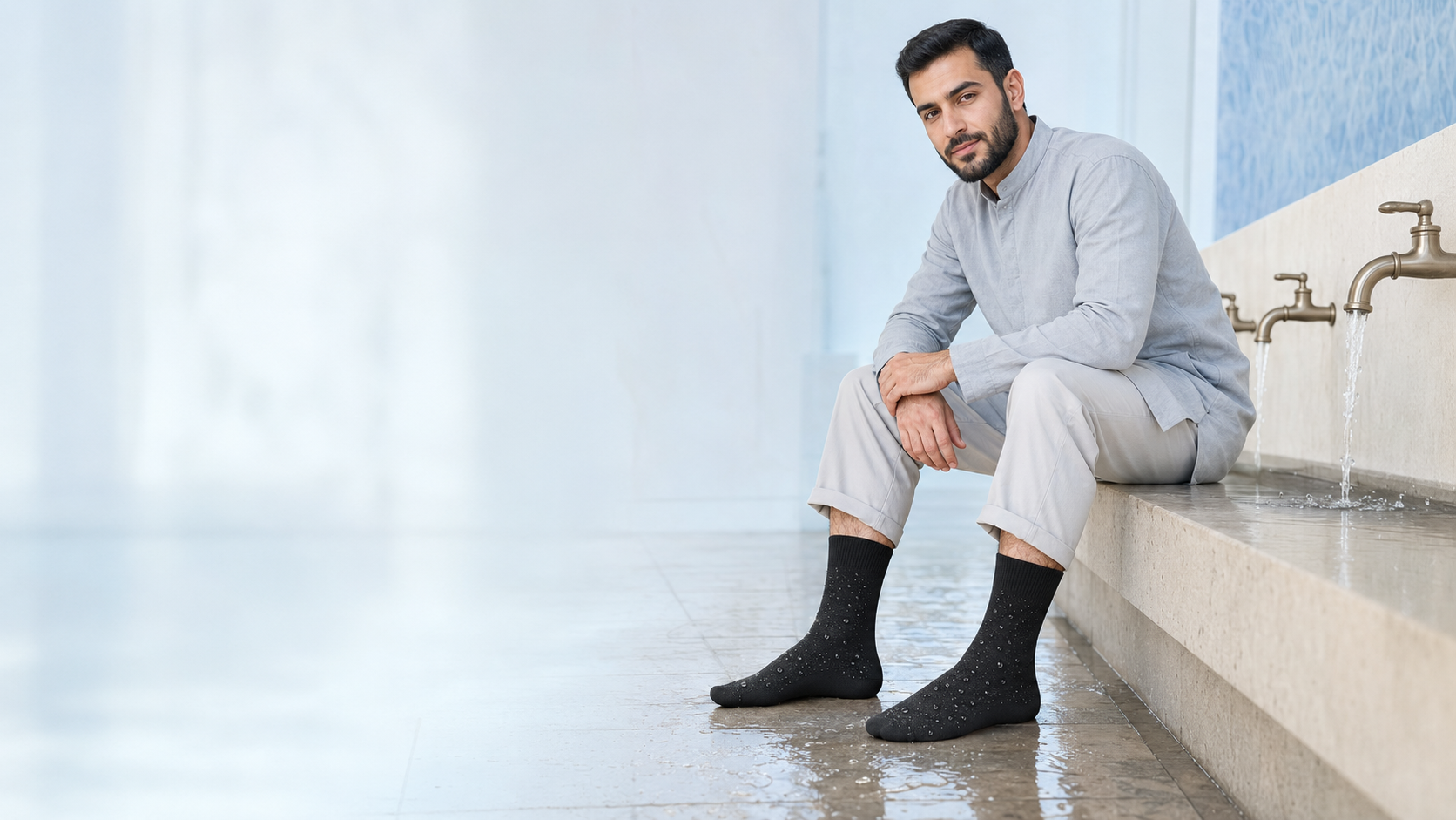 Middle Eastern Muslim model wearing black Wudu or Wudhu waterproof socks near an ablution area